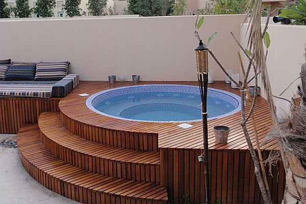 Inground tile hot tub wrapped in wood 