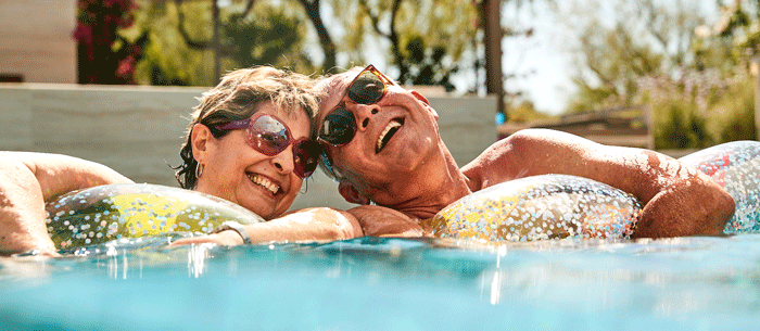 Senior couple relaxing in a pool on floats