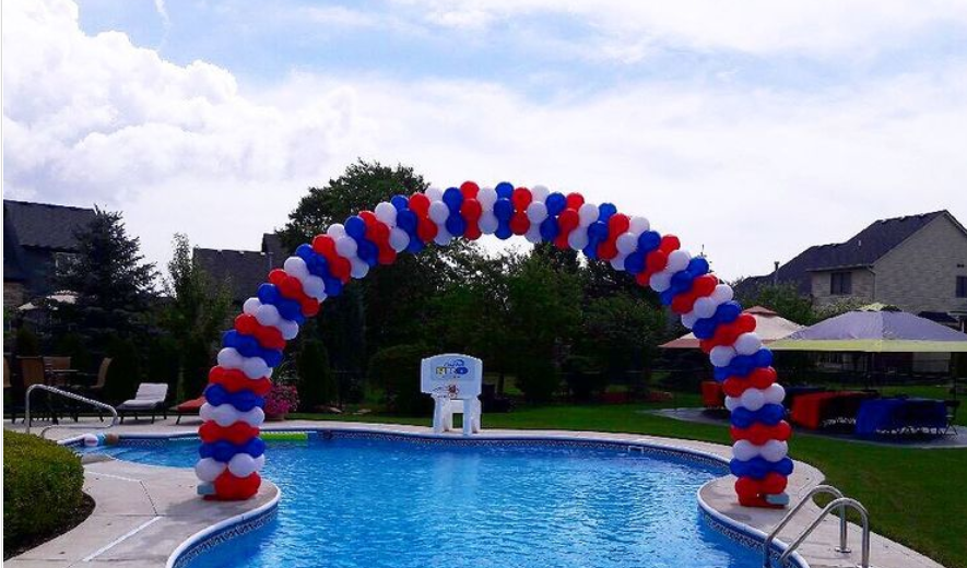 Patriotic red, white and blue balloon archway over pool