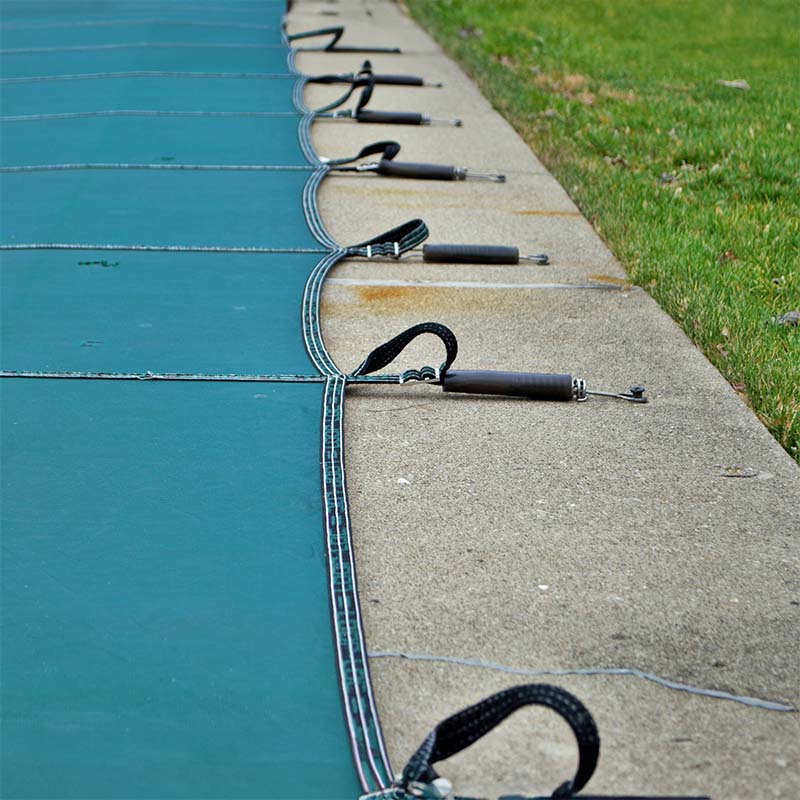 Pool safety cover with straps and anchors